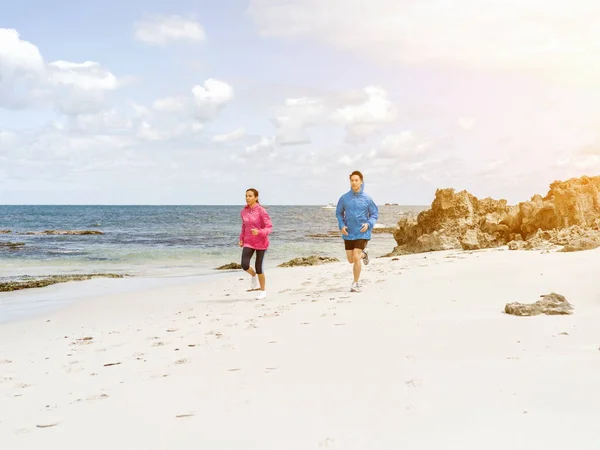 Jeune couple courant le long de la mer — Photo