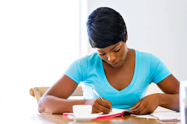 Young woman writing in an agenda at home or office — Stock Photo, Image