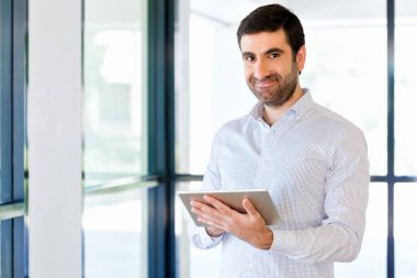 Genç yakışıklı işadamı onun touchpad ayakta kullanma office