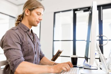 Bilgisayarda çalışan yakışıklı işadamı