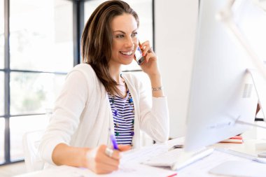 iş kadını ofiste cep telefonu ile
