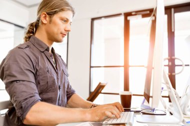 Bilgisayarda çalışan yakışıklı işadamı