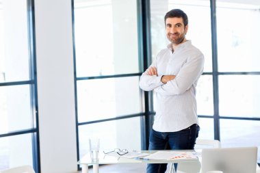 Ofiste duran genç beyaz iş adamı