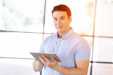 Genç yakışıklı işadamı onun touchpad ayakta kullanma office