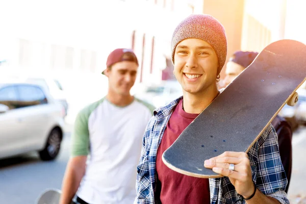 Teenager boy walking at the street with his skateboard — Stock Photo, Image