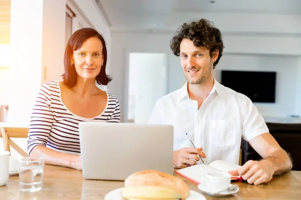 Felice coppia moderna che lavora sul computer portatile a casa — Foto Stock