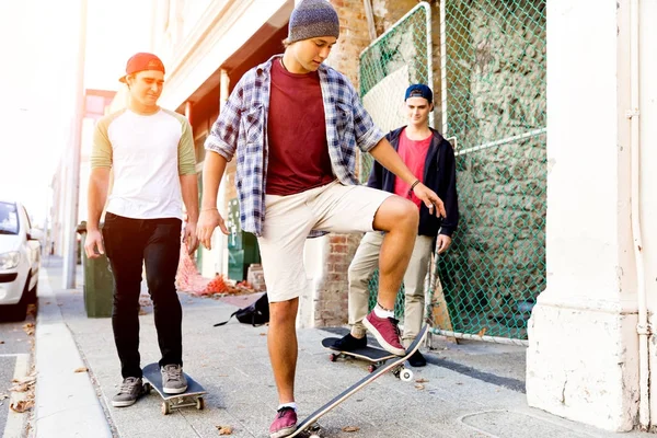 Amici adolescenti che camminano per strada con gli skateboard — Foto Stock