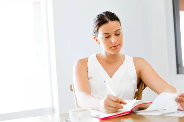 Fiatal nő egy napirend otthon vagy az irodában írásban — Stock Fotó