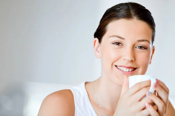 Mujer joven feliz con taza de té o café en casa — Foto de Stock