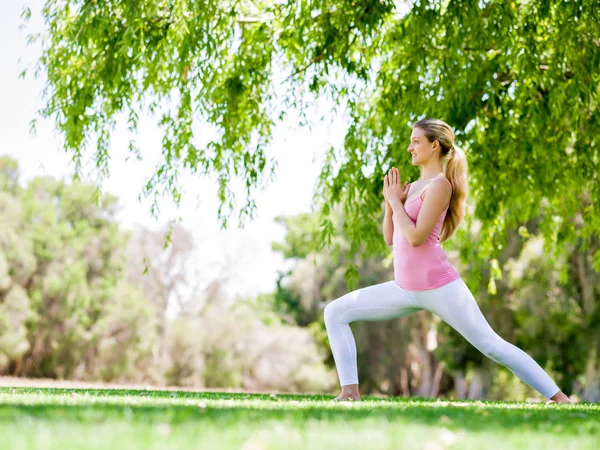 Parkta yoga yapan genç kadın. — Stok fotoğraf