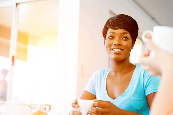 Happy young woman with cup of tea or coffee at home — Stock Photo, Image