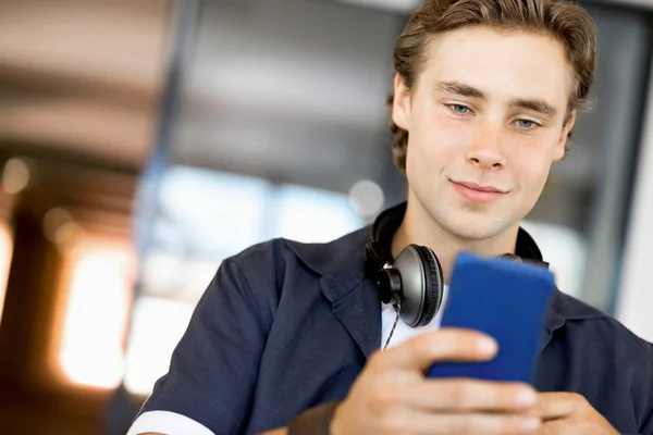 Selbstbewusster junger Mann in schicker Freizeitkleidung mit Handy — Stockfoto