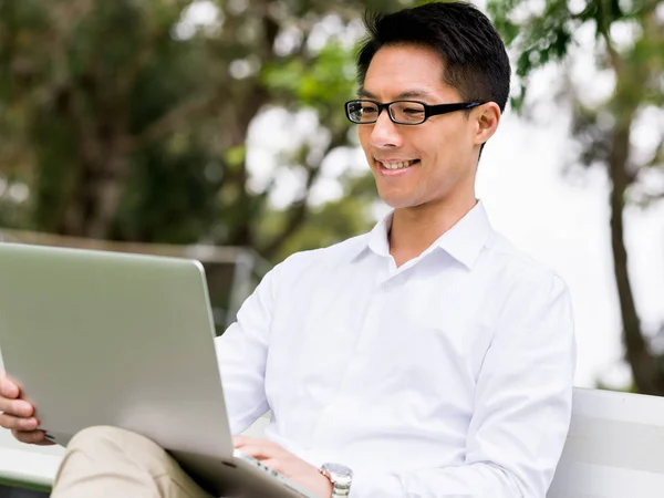 Junger Geschäftsmann sitzt mit Laptop im Freien — Stockfoto