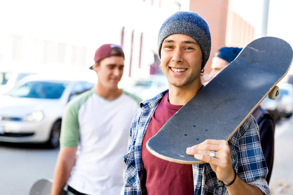 少年男孩走在街上与他的滑板 — 图库照片