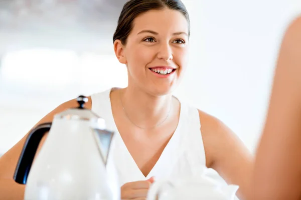 Young woman with her friend sitting at the table — Stock Photo, Image