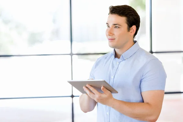 Νεαρός επιχειρηματίας όμορφος χρήση του touchpad στέκεται στο office — Φωτογραφία Αρχείου