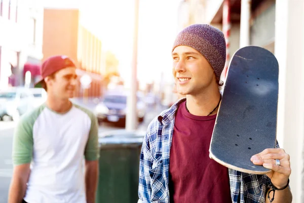 Amigos adolescentes caminando por la calle con patinetas —  Fotos de Stock