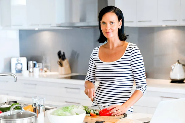 Mulher bonita de pé na cozinha e cozinhar — Fotografia de Stock