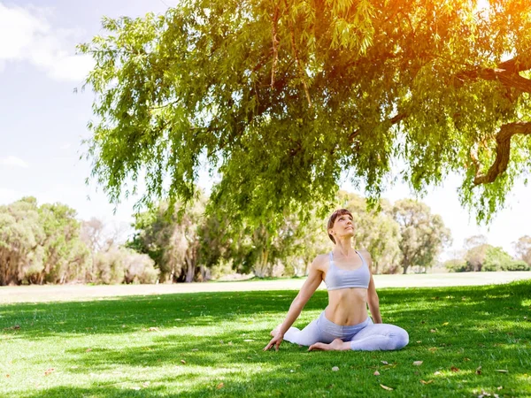 Młoda kobieta praktykująca jogę w parku — Zdjęcie stockowe