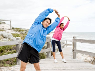 Egzersizleri yapıyor deniz kenarında genç Çift