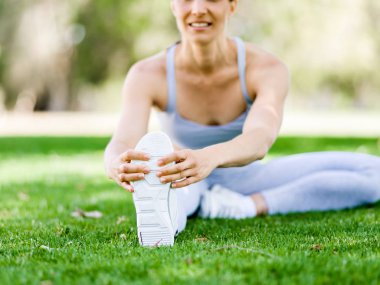 Parkta egzersiz yapan genç bir kadın.