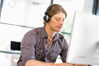 Kulaklıklar ile ofiste genç adam