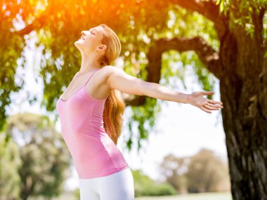 Parkta egzersiz yapan genç bir kadın.