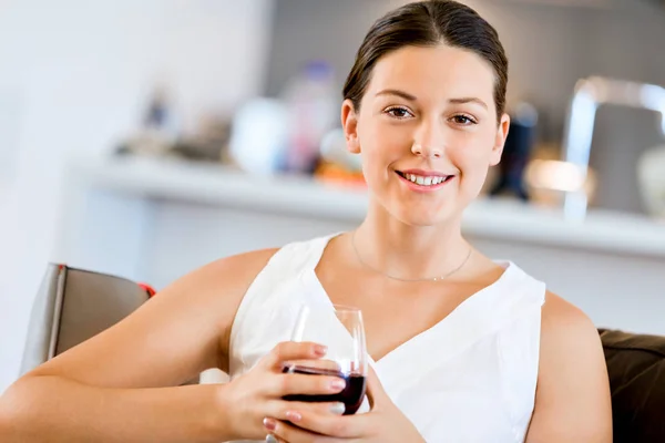 Beautiful young woman holding glass with red wine — Stock Photo, Image