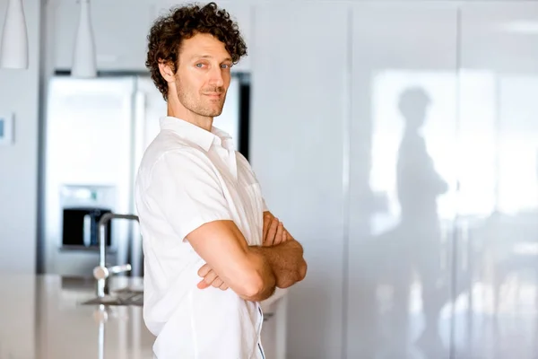 Портрет розумного молодого чоловіка, що стоїть на кухні — стокове фото