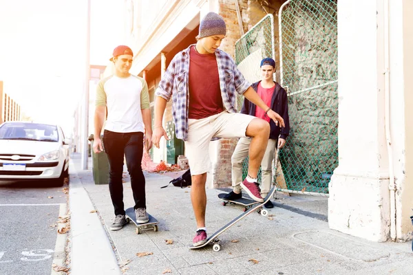 Tonåriga vänner gå på gatan med skateboards — Stockfoto