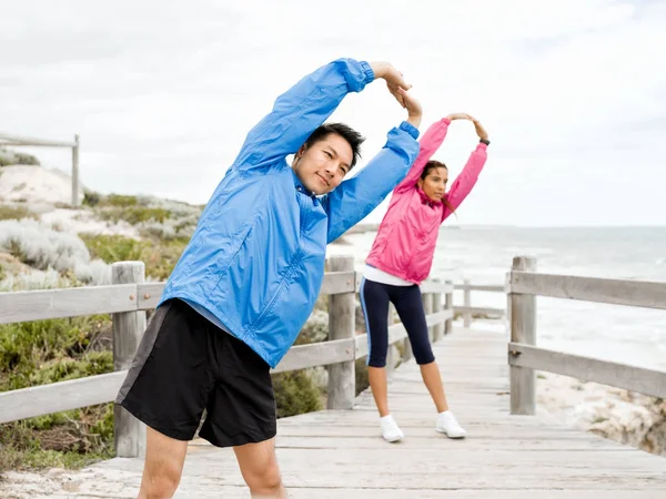 Egzersizleri yapıyor deniz kenarında genç Çift
