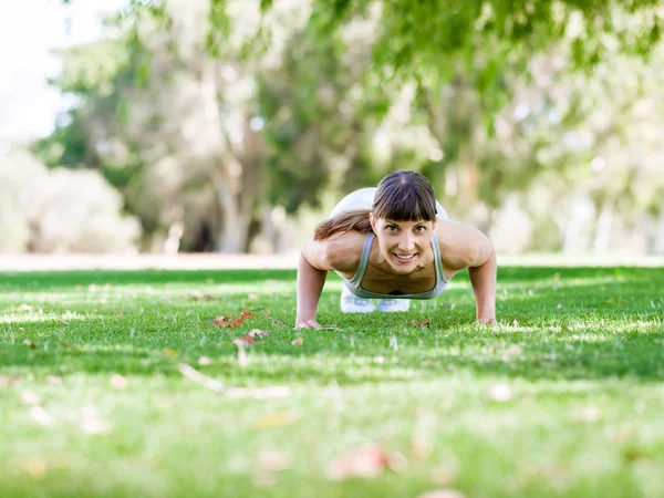 Jeune femme faisant de l'exercice dans le parc — Photo