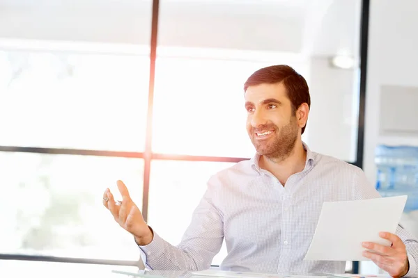 Stilig ung man håller papper i office — Stockfoto