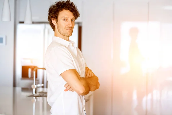 Портрет розумного молодого чоловіка, що стоїть на кухні — стокове фото