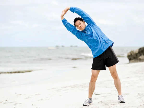 Joven haciendo ejercicio en la playa — Foto de Stock