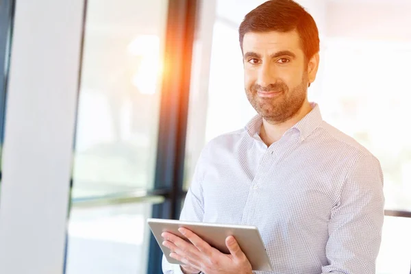 Junger hübscher Geschäftsmann mit Touchpad im Büro — Stockfoto