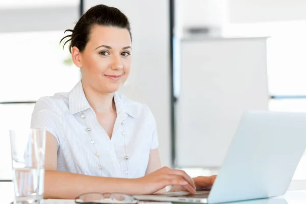 Porträt einer Geschäftsfrau, die im Büro am Computer arbeitet — Stockfoto