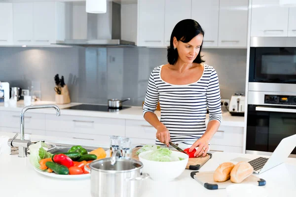 Mulher bonita de pé na cozinha e cozinhar — Fotografia de Stock