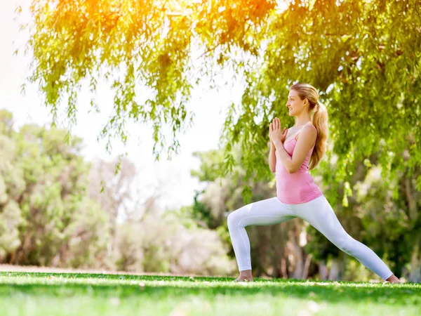 Parkta yoga yapan genç kadın. — Stok fotoğraf