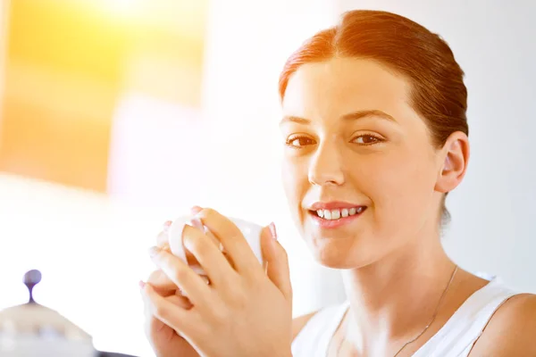 Mujer joven feliz con taza de té o café en casa —  Fotos de Stock