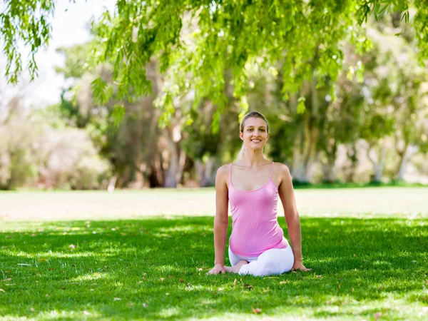 Jonge vrouw doet yoga in het park — Stockfoto