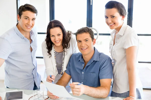 Groep van gelukkige jonge zakenmensen in een vergadering — Stockfoto