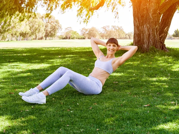 Jeune femme faisant de l'exercice dans le parc — Photo