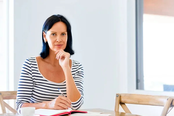 Vacker kvinna skriva en agenda hemma eller på kontoret — Stockfoto