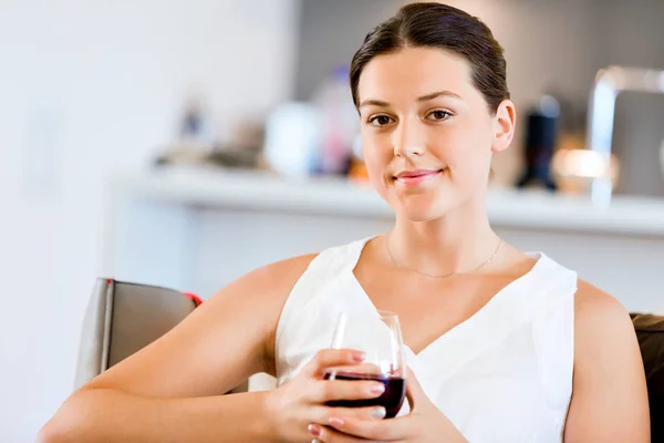Belle jeune femme tenant un verre avec du vin rouge — Photo