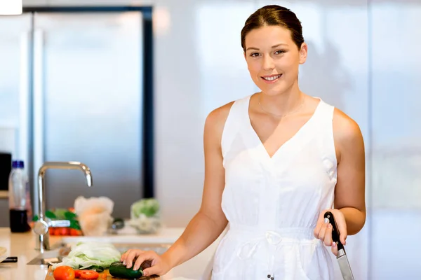 Schöne Frau steht in der Küche und lächelt — Stockfoto