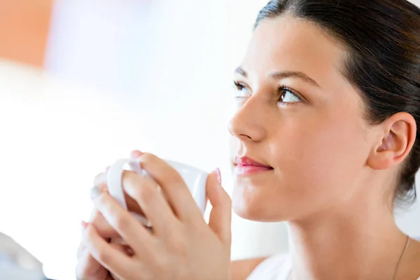 Mujer joven feliz con taza de té o café en casa —  Fotos de Stock