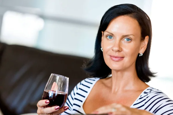 Όμορφη νεαρή γυναίκα που κρατώντας το ποτήρι με κόκκινο κρασί — Φωτογραφία Αρχείου
