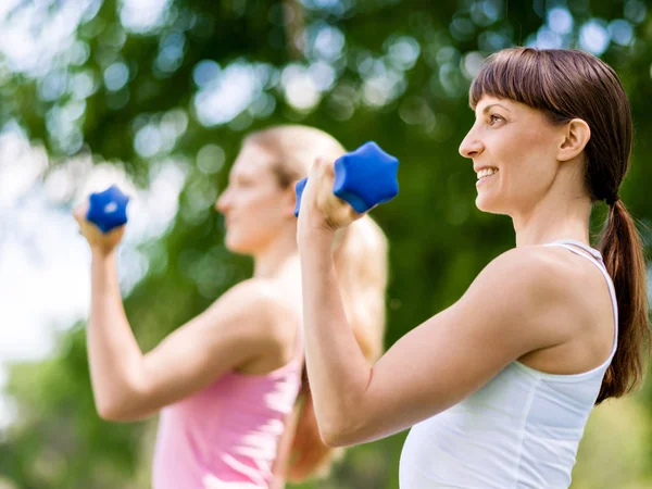 Portrait de femmes gaies en tenue de fitness exercice avec haltère — Photo