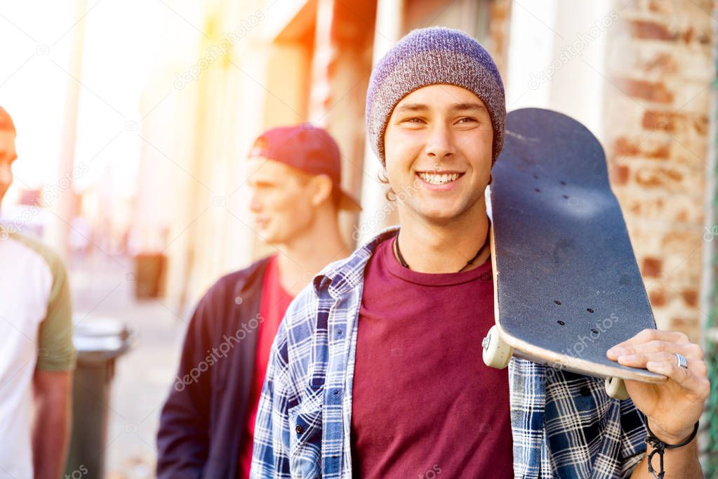 Teenager boy walking at the street with his skateboard